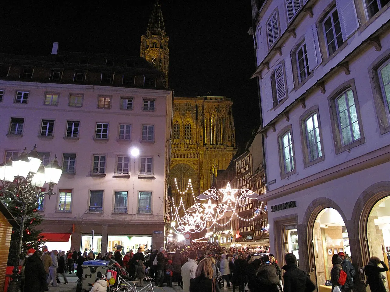 Christmas lights and crowds in a street leading to Strasbourg Cathedral