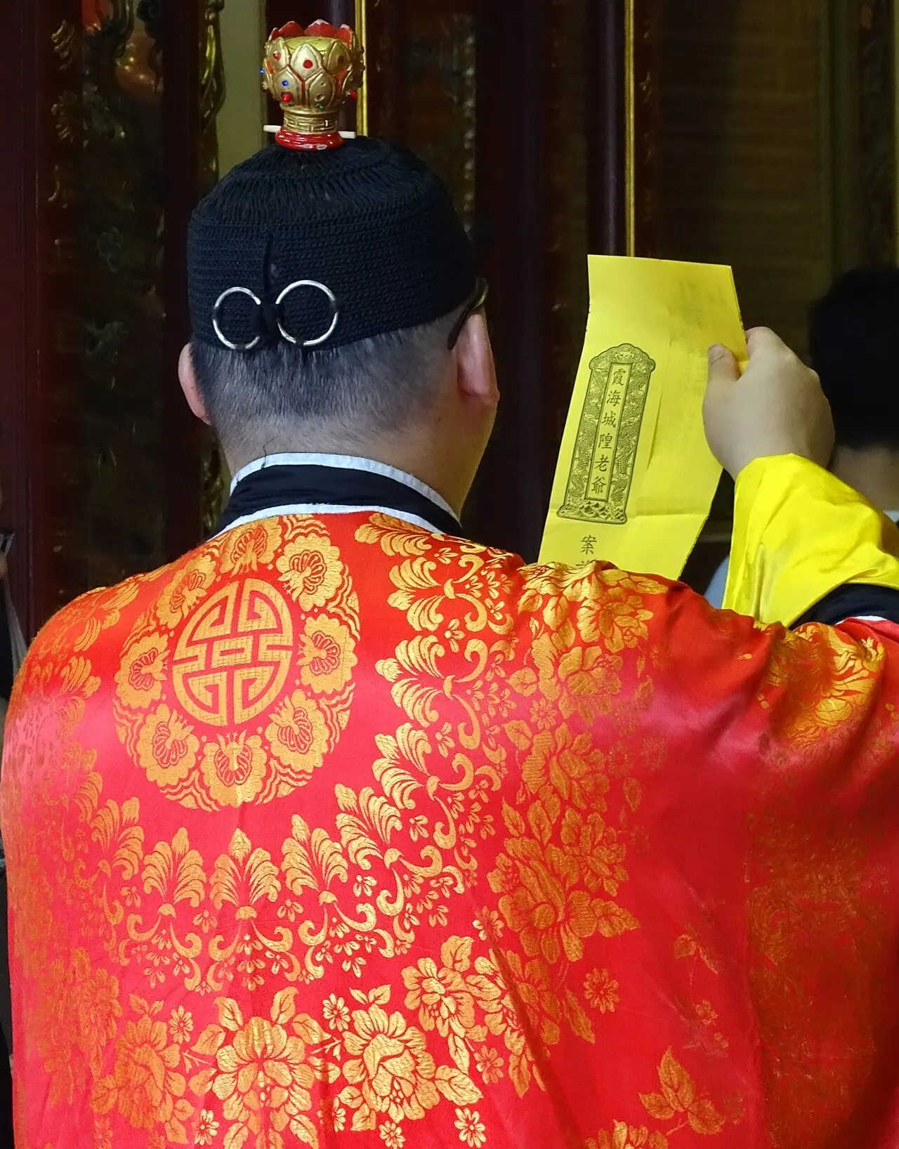 A priest praying inside Taipei Xiahai City God Temple on Dihua Street