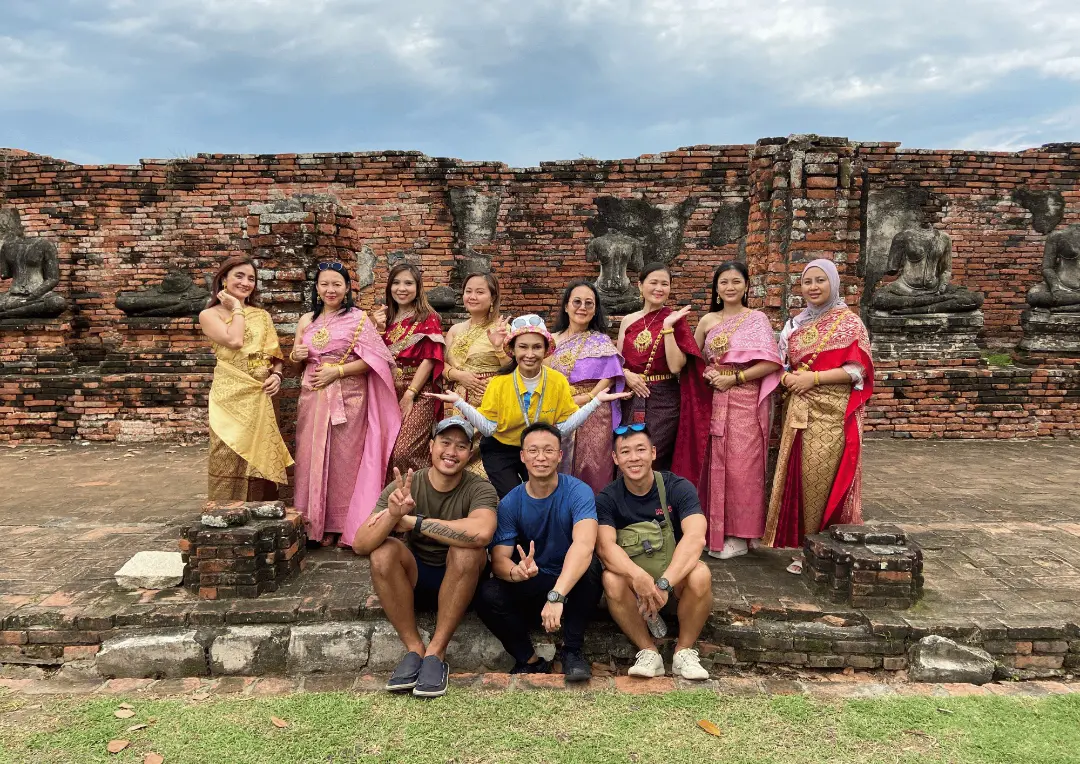 アユタヤの寺院遺跡で、タイの伝統衣装を着た旅行者とMyProGuideガイド